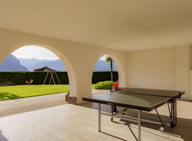 Famiglia che gioca a ping pong durante le vacanze in un appartamento al Wieserhof sulla Strada del Vino dell'Alto Adige ad Andriano