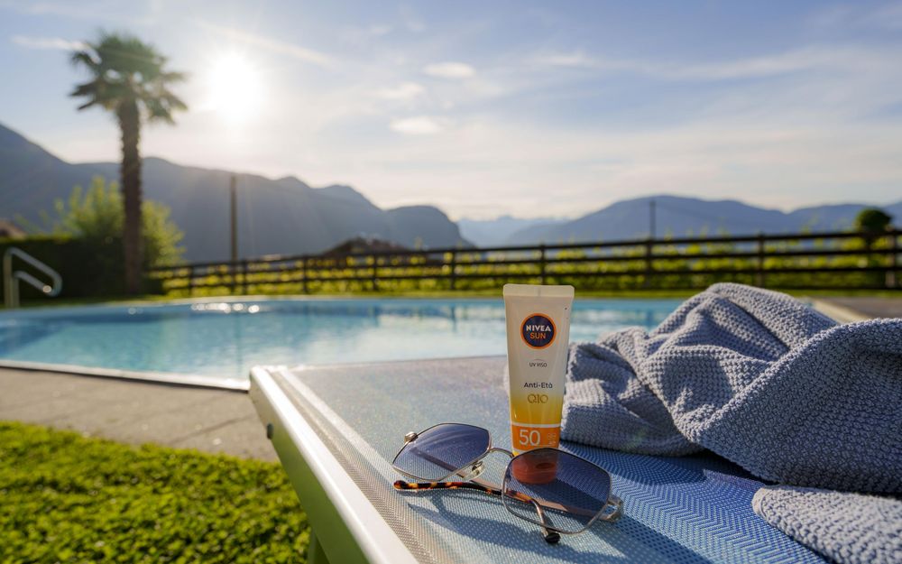 Outdoor swimming pool with sunbathing lawn at Wieserhof apartments in Andrian, South Tyrol Wine Road, summer 2024