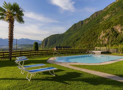 Piscina all'aperto con prato e appartamenti vacanze al Wieserhof ad Andriano sulla Strada del Vino in Alto Adige